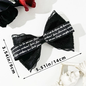 Detail of Gothic black lace bow hair clip with letter ribbon and spring metal clasp