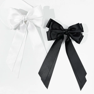 Close-up of elegant double-layered satin bow hair clips in black and white colors