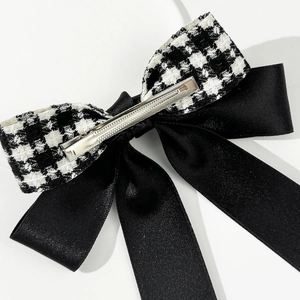 Detail view of the silver metal spring clip on a vintage houndstooth bow hairpin