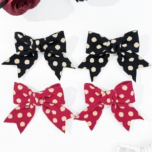Detailed set of 4 polka dot bow hair clips in black and dark red fabric with metal pins