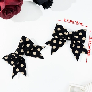 Close-up of black and white polka dot bow hair clip with 3.54 inch size measurement