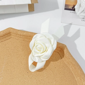 Barrette à cheveux fleur de camélia blanc avec rubans en satin sur un plateau