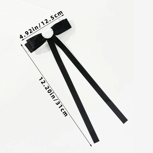 Detailed view of ballet style black satin bow clip with lace heart, 12.5cm width measurement
