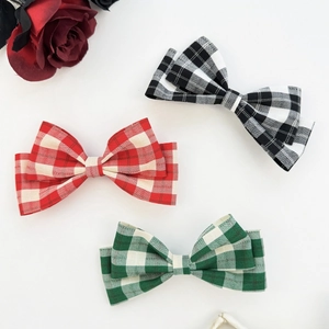 Detailed view of plaid bow hair clips in red, black, and green checkered patterns