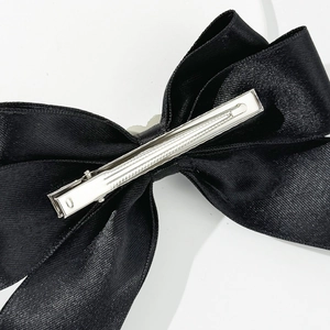 Detailansicht der schwarzen Satin-Schleife mit einer robusten silbernen Metall-Krokodilklemme