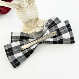 Detailed view of black and white plaid bow hair clip with a sturdy silver metal alligator clip