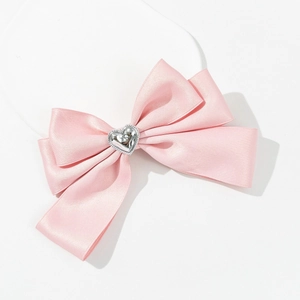 Detail der rosa Satinschleife Haarklammer mit silbernem Herzdekor und elastischem Band