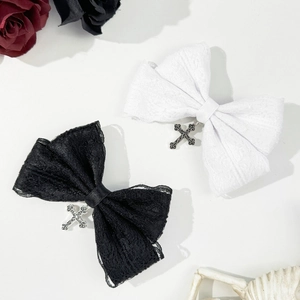 Detail of black and white lace bow hair clips with vintage silver gothic cross pendants