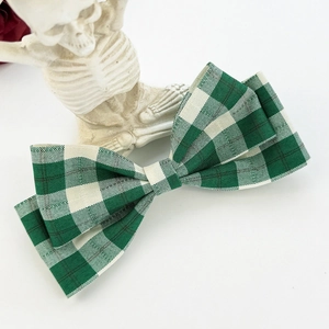 Detail of green and white gingham bow hair clip held by a creative skeleton hand stand