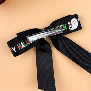 Detail of Halloween bow hair clip featuring ghost print and silver metal alligator clip