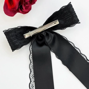 Dettaglio del fermaglio per capelli in pizzo nero con clip a coccodrillo e nastro in raso
