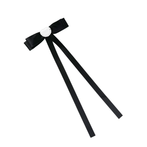Elegant ballet style black satin bow hair clip with white heart pearl accent on white background