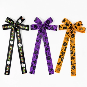 Close-up of three Halloween ribbon hair clips in black, purple and orange with spooky prints