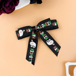 Detail of black grosgrain Halloween bow clip with Happy Halloween text and ghost prints