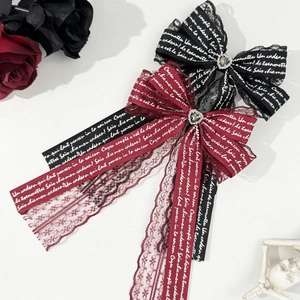 Détail de barrettes nœuds gothiques avec strass en cœur et finitions en dentelle fine