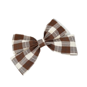 Elegant vintage plaid bow hair clip with brown and cream patterns on a white background