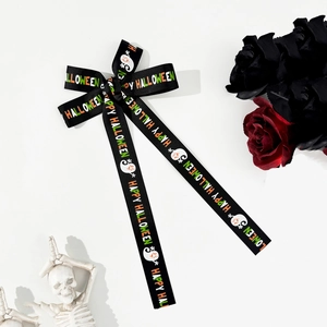 Detail of Halloween bow hair clip with ghost patterns and Happy Halloween text