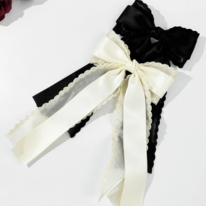 Elegant satin bow hair clip with lace edges and long ribbons in black and beige