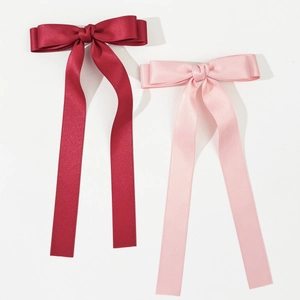 Detail von hochwertigen Satin-Haarspangen mit langen Bändern in Burgund und Rosa Farben