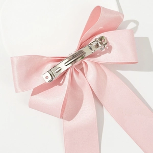 Détail arrière du nœud en satin rose avec clip en métal argenté gravé CLIP PARIS de qualité
