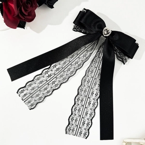 Dettaglio del fermaglio per capelli in raso nero e pizzo con strass a cuore lucido