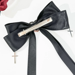 Détail de la pince à cheveux nœud en satin noir avec croix argentées et clip bec de canard