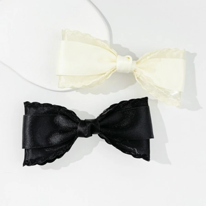Elegant double-layered bow hair clips in black and cream white with delicate wavy lace edges