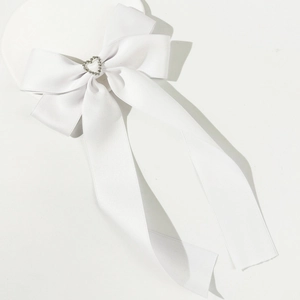 Détail d'une barrette à cheveux en satin blanc avec un cristal en forme de cœur brillant