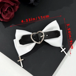 Détail d'un nœud papillon en satin blanc avec boucle cœur noire et pendentifs croix