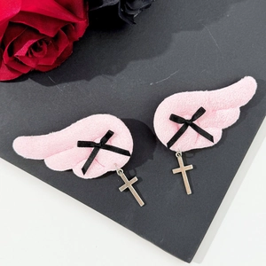 Gothic pink plush wing hair clips with black bows and silver cross charms on black background