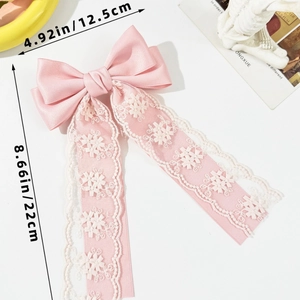 Detail of pink bow hair clip with floral lace streamers showing 8.66-inch total length