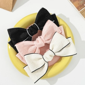 Elegant jacquard bow hair clips in black, pink and cream white with contrast piping