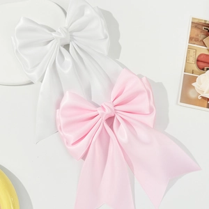 Elegant oversized satin bow hair clip with long ribbons in white and pink colors