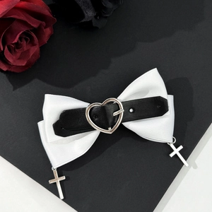Détail de la pince à cheveux nœud en satin avec pendentifs cœur et croix punk