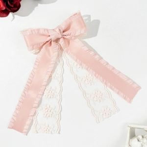 Vue détaillée de la texture du nœud papillon en satin rose et dentelle florale blanche