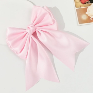 Elegant large pink satin bow hair clip with long ribbons for a sweet aesthetic look