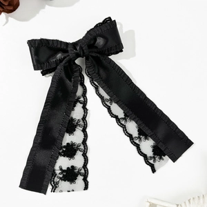 Détail d'un nœud à cheveux noir en dentelle double couche avec broderies florales élégantes