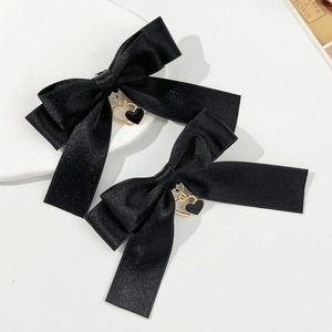 Paire de barrettes à nœuds en satin noir avec pendentifs double cœur dorés