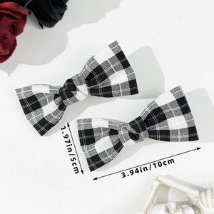 Detailed view of black and white plaid bow hair clips with specific size measurements
