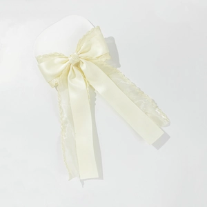Detail view of elegant ivory mesh ribbon hair clip with delicate wavy organza texture
