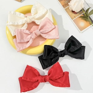 Set of 4 elegant ruffled satin bow hair clips in cream, pink, black, and red colors
