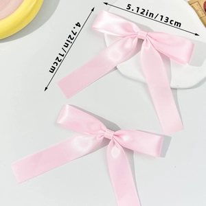 Vue détaillée de deux nœuds en satin rose style ballet mesurant 13cm de large et 12cm de long