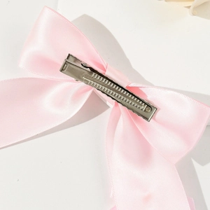 Detailansicht der Rückseite mit silbernem Entenschnabelclip der rosa Satin-Schleife