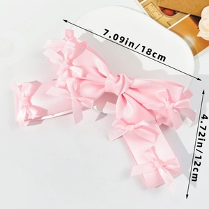 Detail view showing a light pink satin bow hair clip with dimensions of 18cm by 12cm