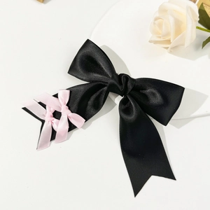 Nahaufnahme der schwarz-rosa Satin-Schleifen-Haarklammer im eleganten Balletcore-Stil