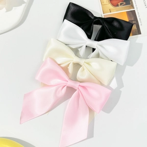 Set of four satin ribbon bow hair clips in black, white, cream, and pink with long tails