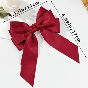 Detail of red satin bow hair clip with ribbons showing dimensions 13cm by 17cm