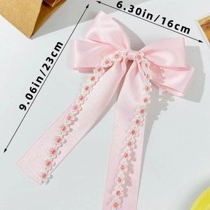 Detailed view of pink satin bow hair clip with lace flowers showing 23cm length dimensions
