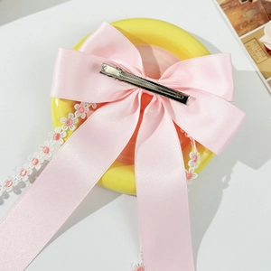 Detailed back view of pink satin bow hair clip with floral lace and metal alligator grip