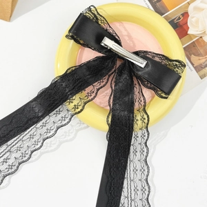 Detailed view of the layered black lace bow hair clip with elegant long flowing ribbons